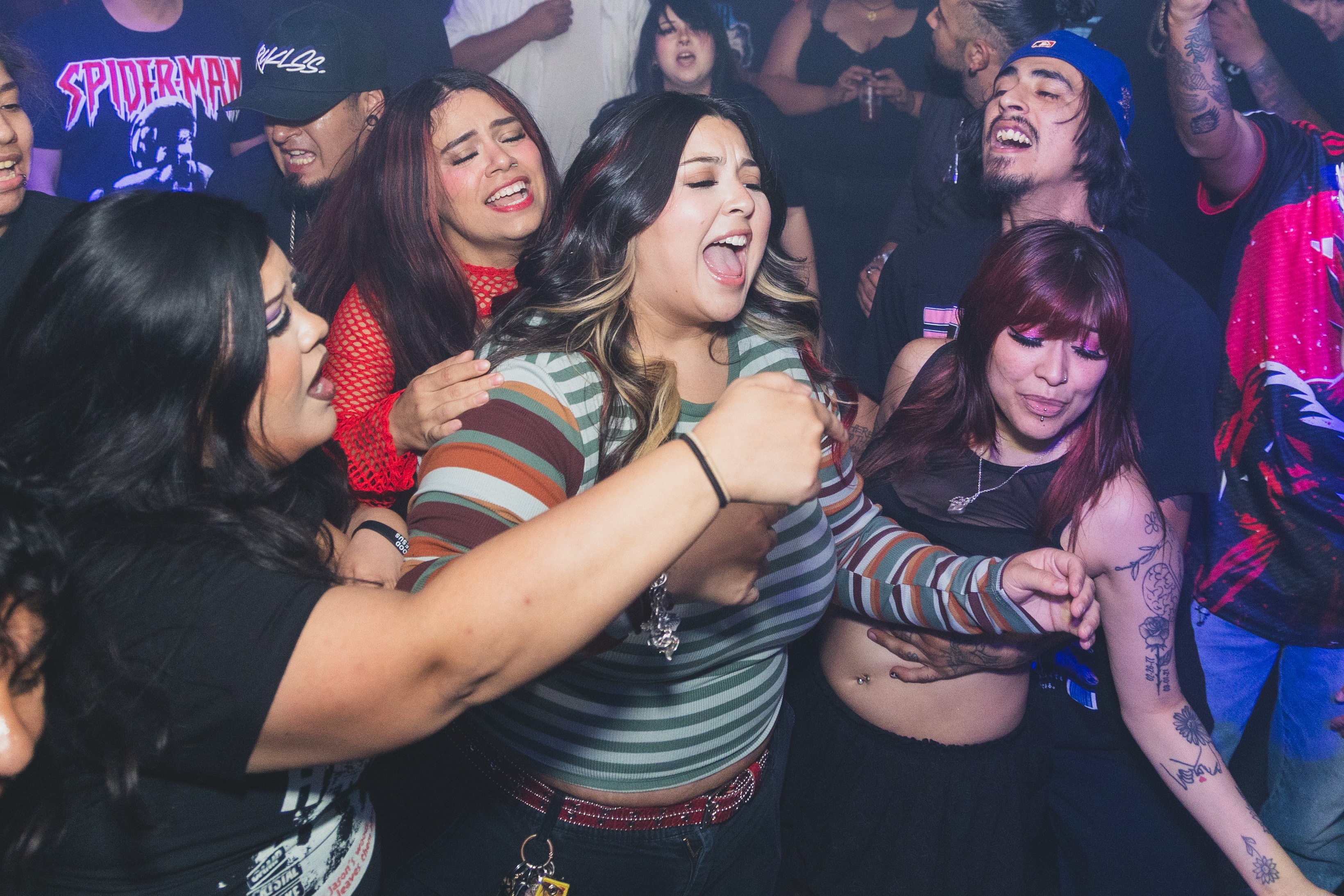 Friends singing and dancing together in the crowd at SATX Emo Club