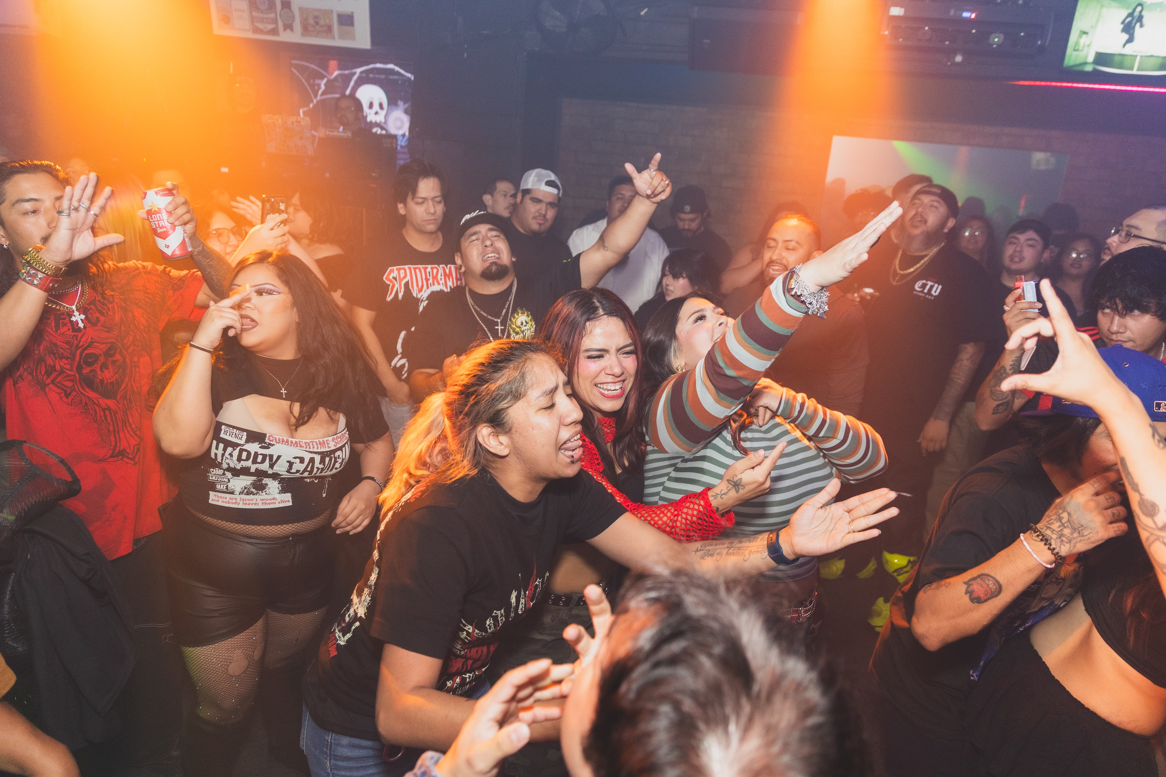 Energetic crowd under orange lights at SATX Emo Club