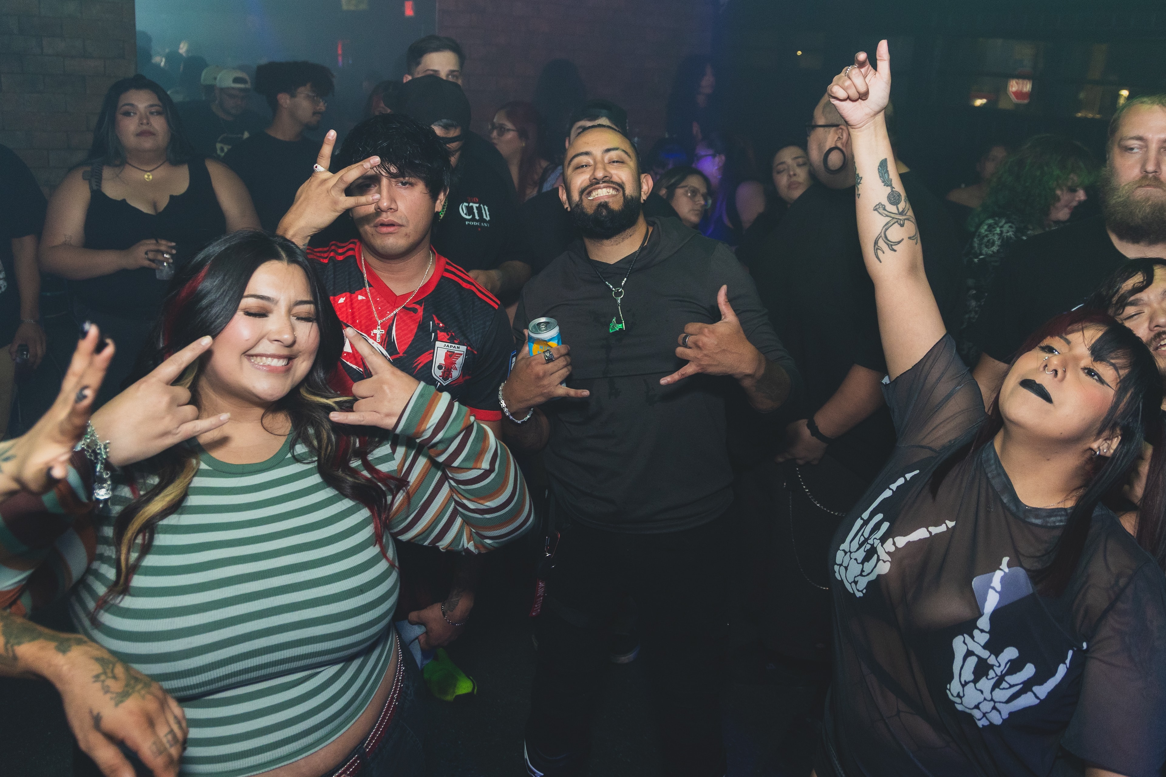 Crowd throwing peace signs and hands up at SATX Emo Club