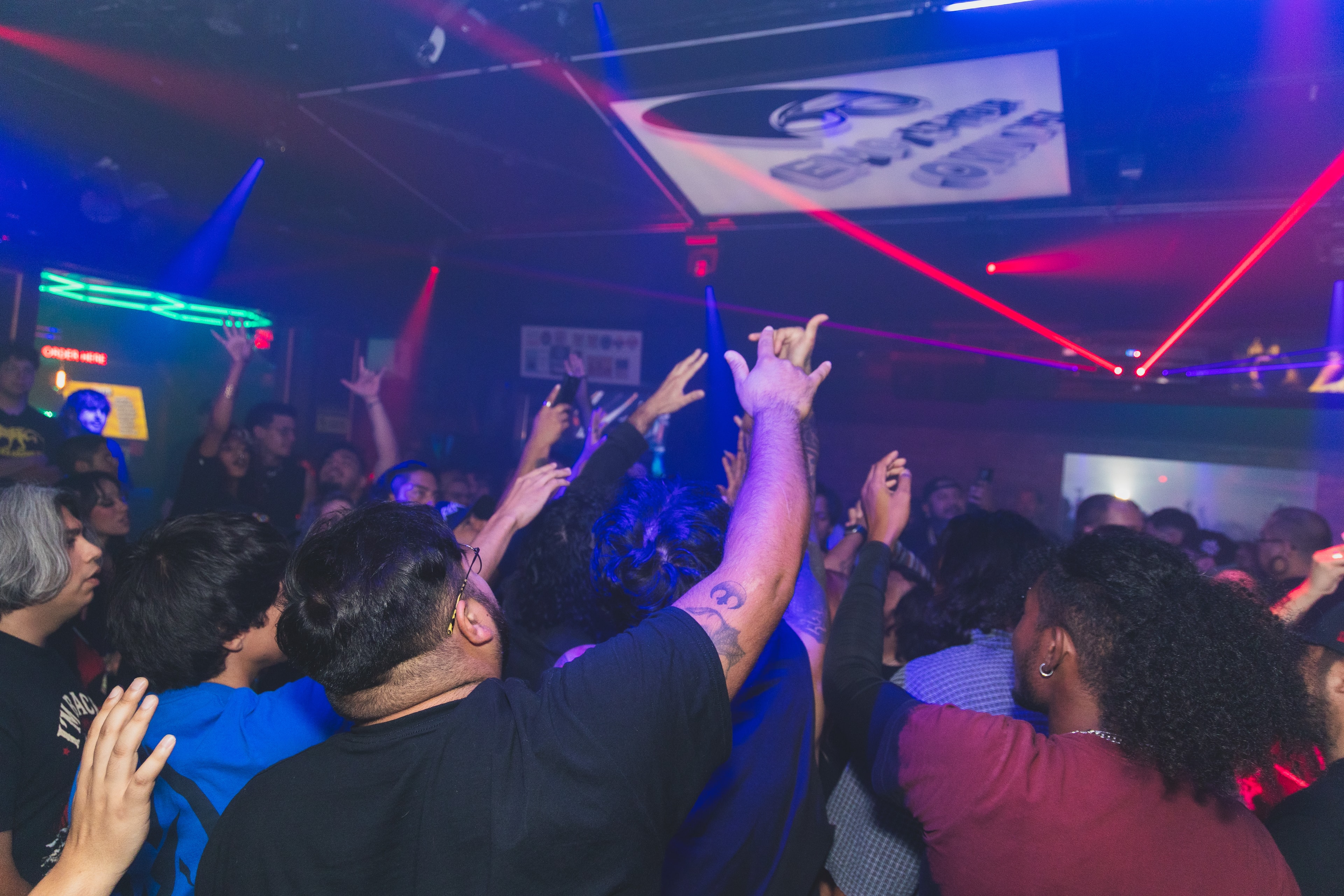 Crowd dancing under neon lights at SATX Emo Club