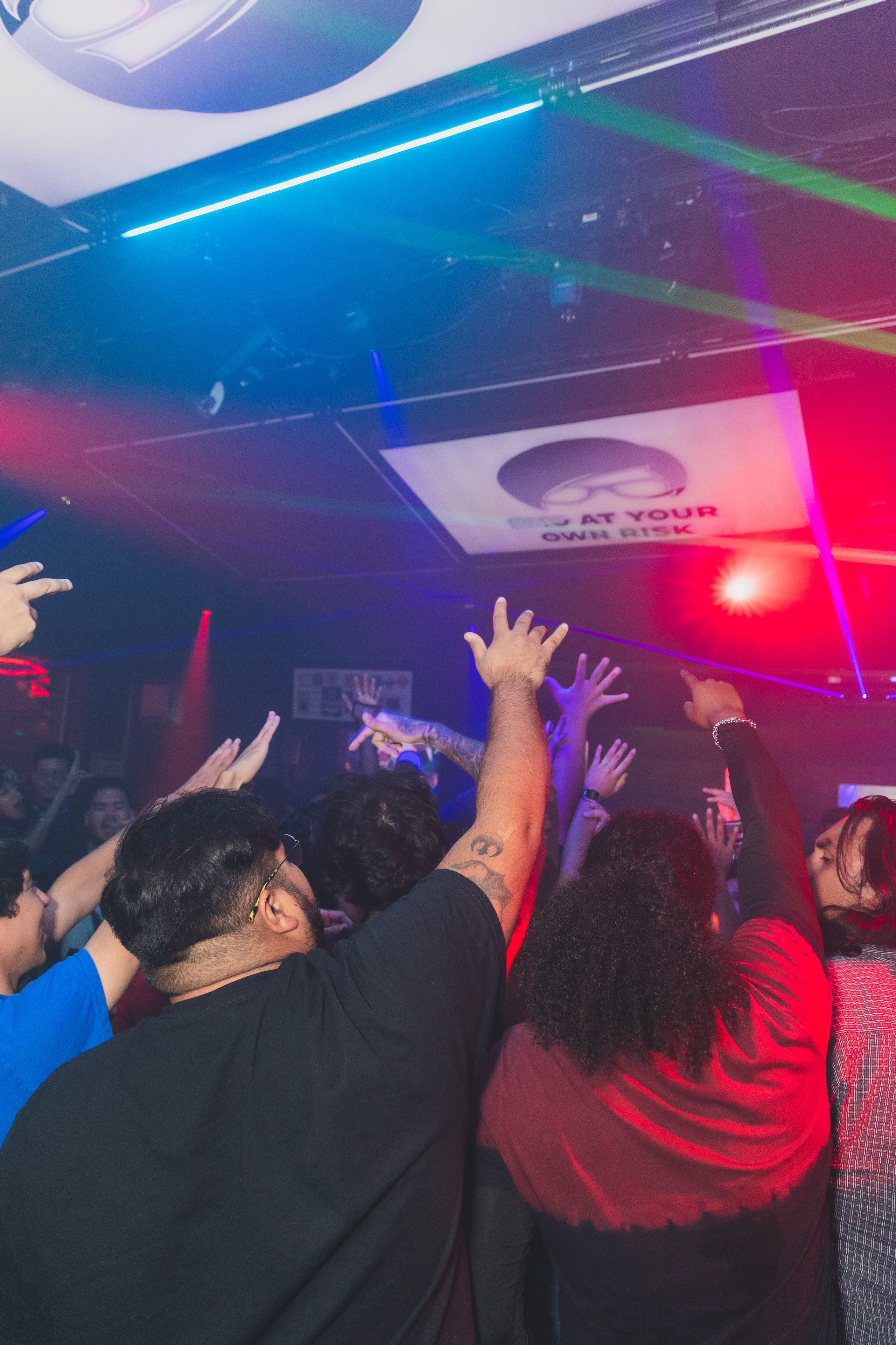 Crowd dancing under colorful lights at SATX Emo Club