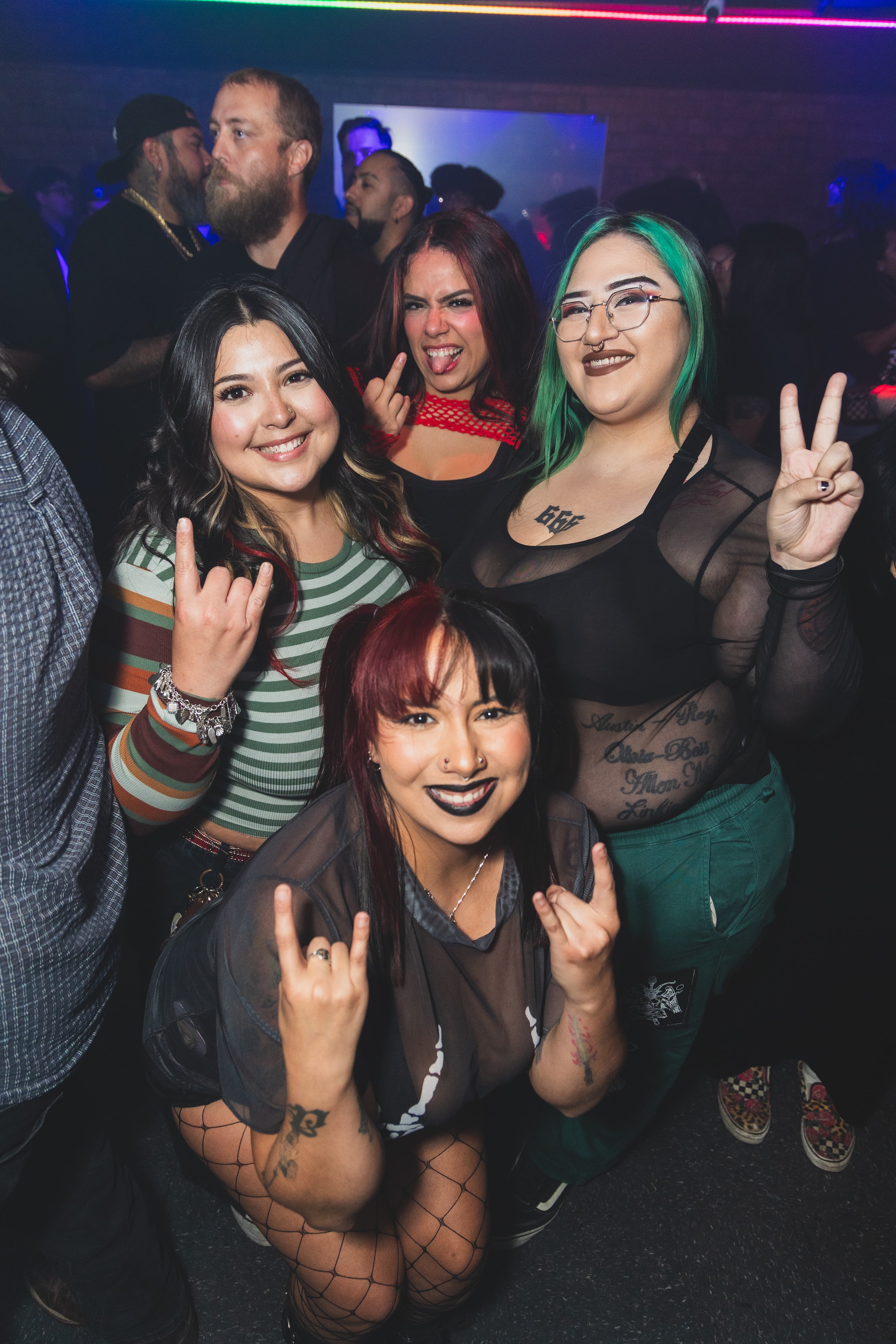 Four friends throwing horns on the dance floor at SATX Emo Club