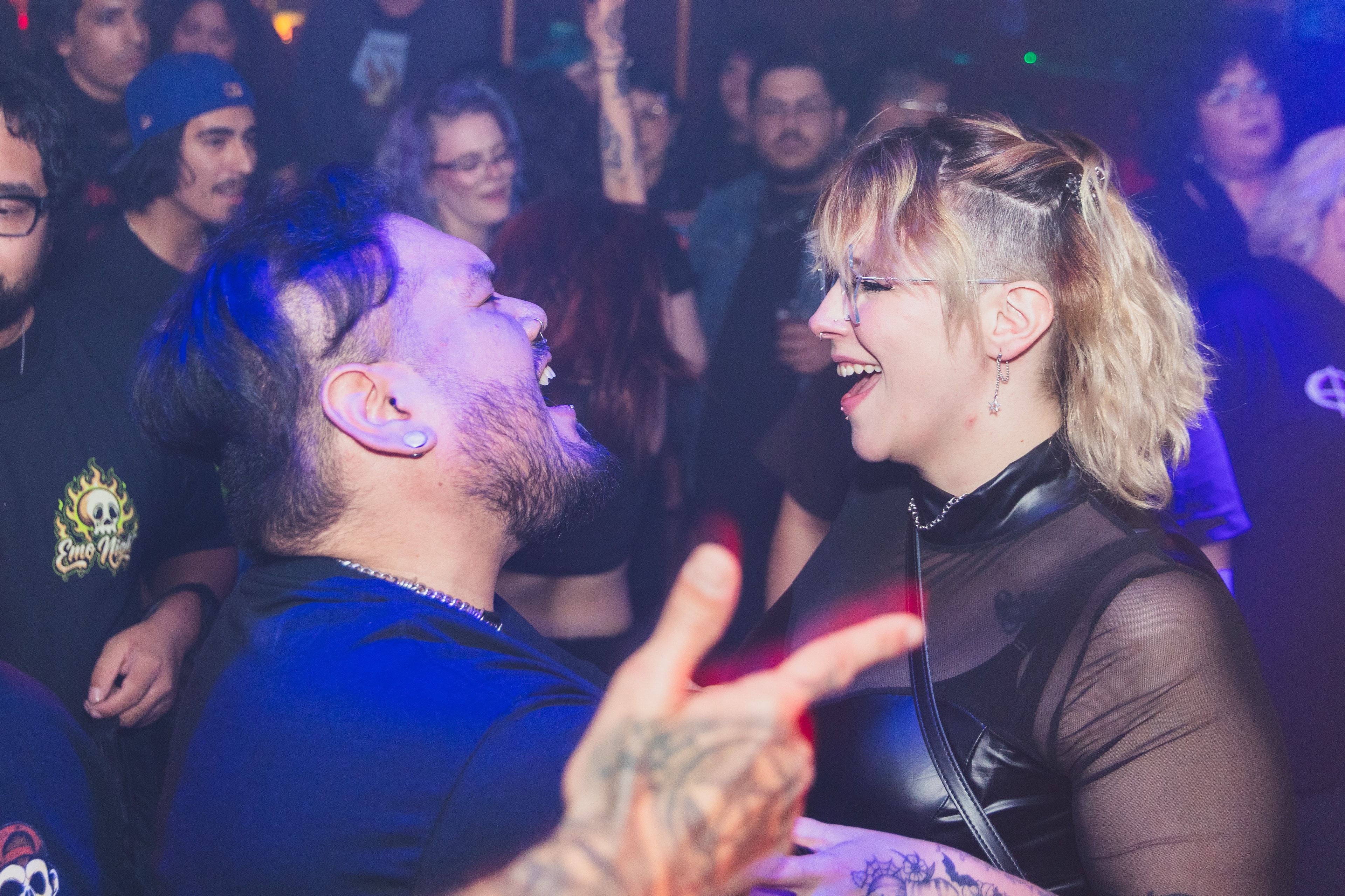Two attendees laughing together on the dance floor at SATX Emo Club