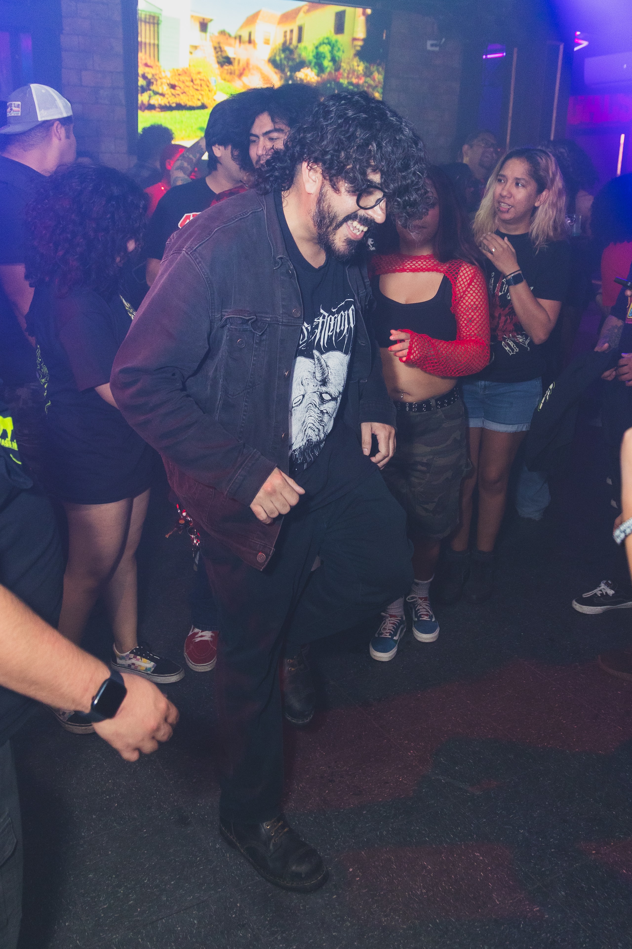Attendee in denim jacket dancing at SATX Emo Club
