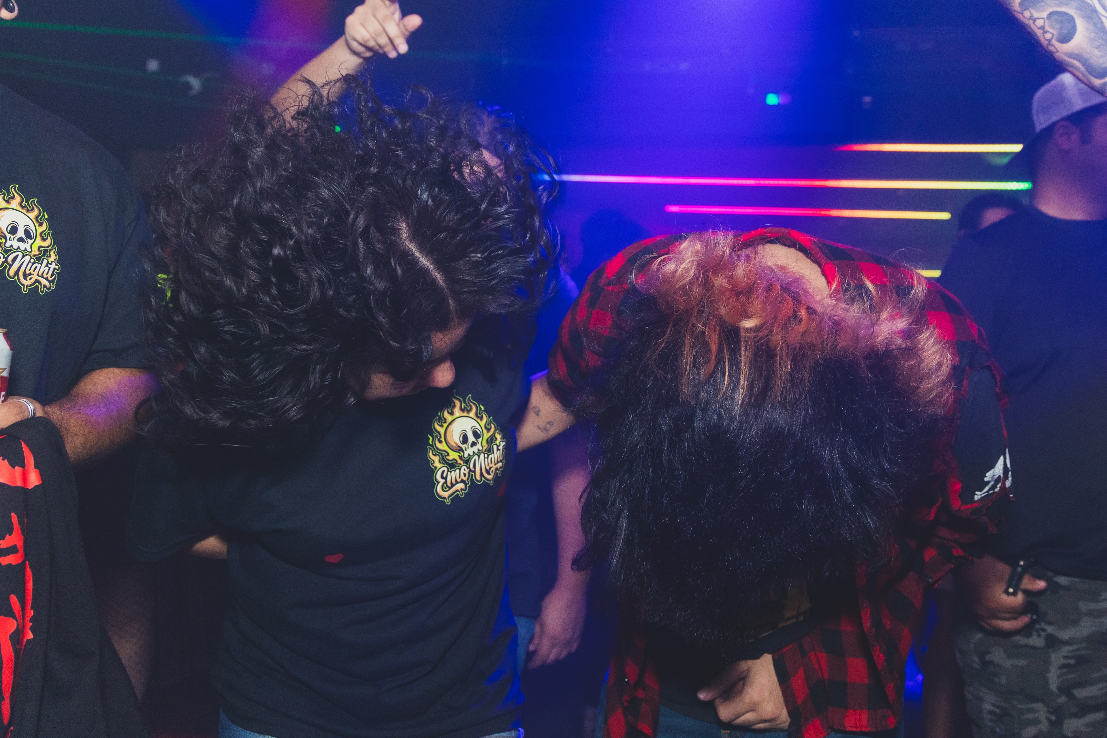 Two attendees headbanging together under laser lights at SATX Emo Club