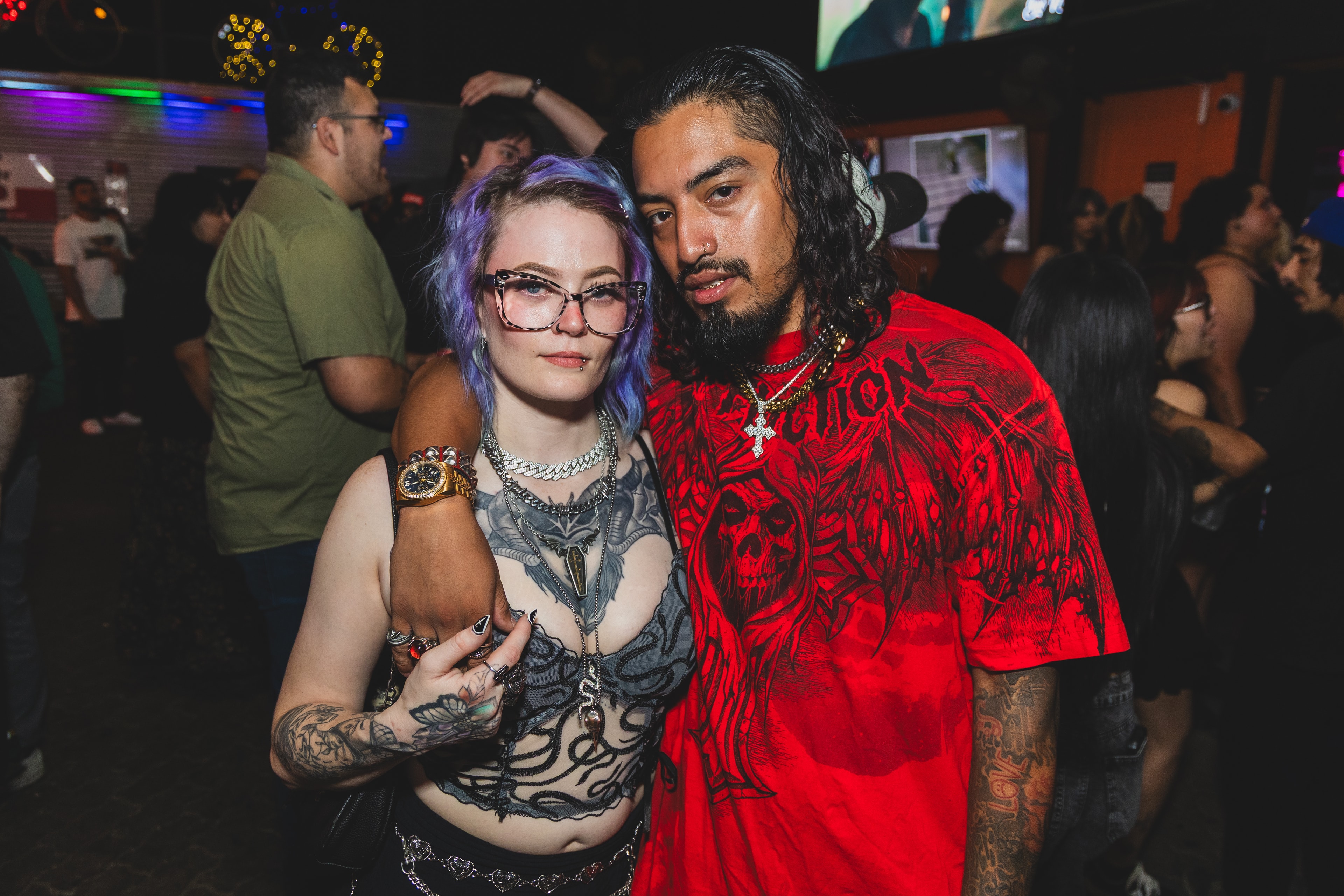 Heavily tattooed couple posing together at SATX Emo Club