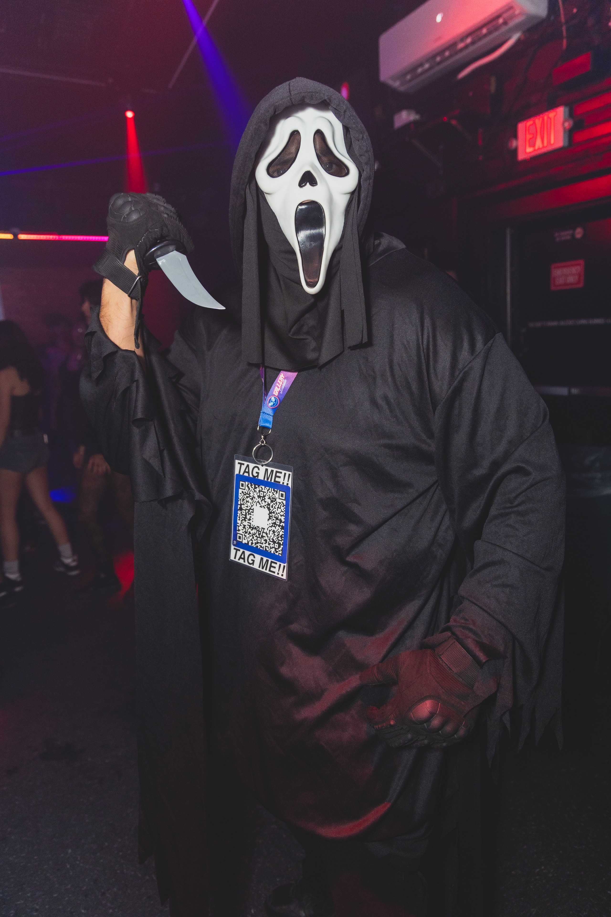 Ghostface costume attendee with TAG ME QR code lanyard at SATX Emo Club