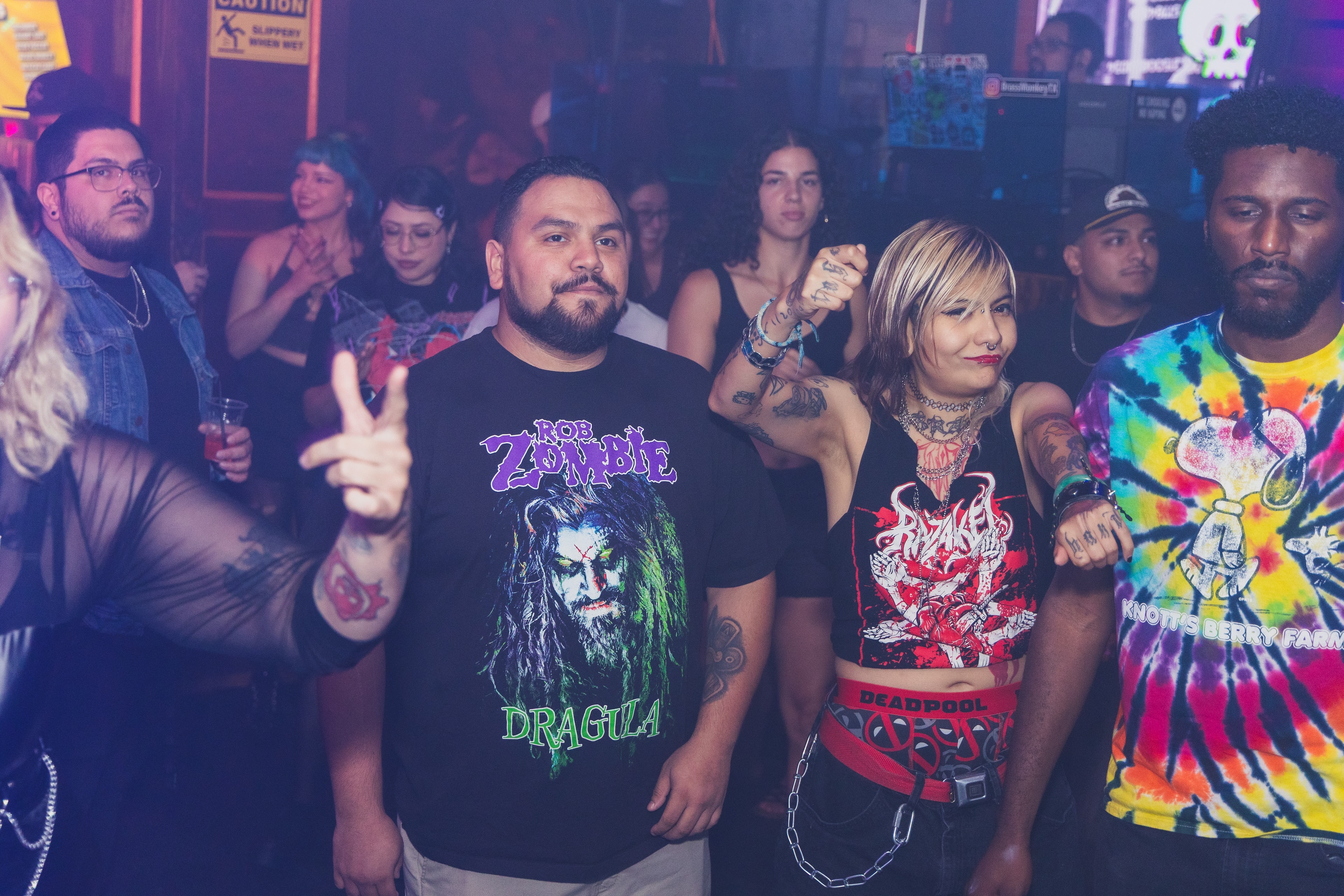 Rob Zombie Dragula tee and Deadpool crop top couple with tie-dye Knott's Berry Farm shirt at SATX Emo Club