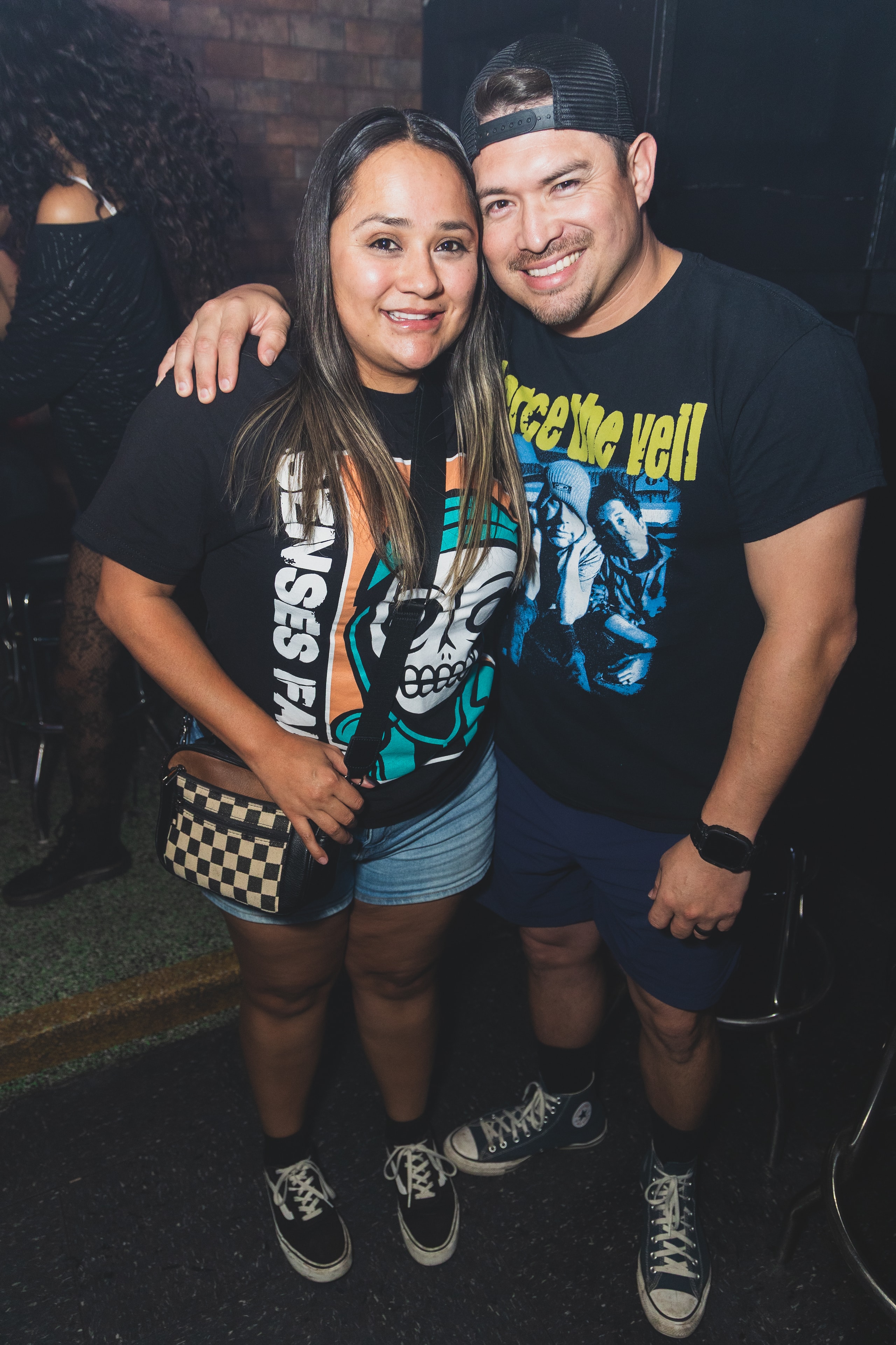 Couple in Senses Fail and Pierce the Veil tees with Converse and Vans smiling at SATX Emo Club